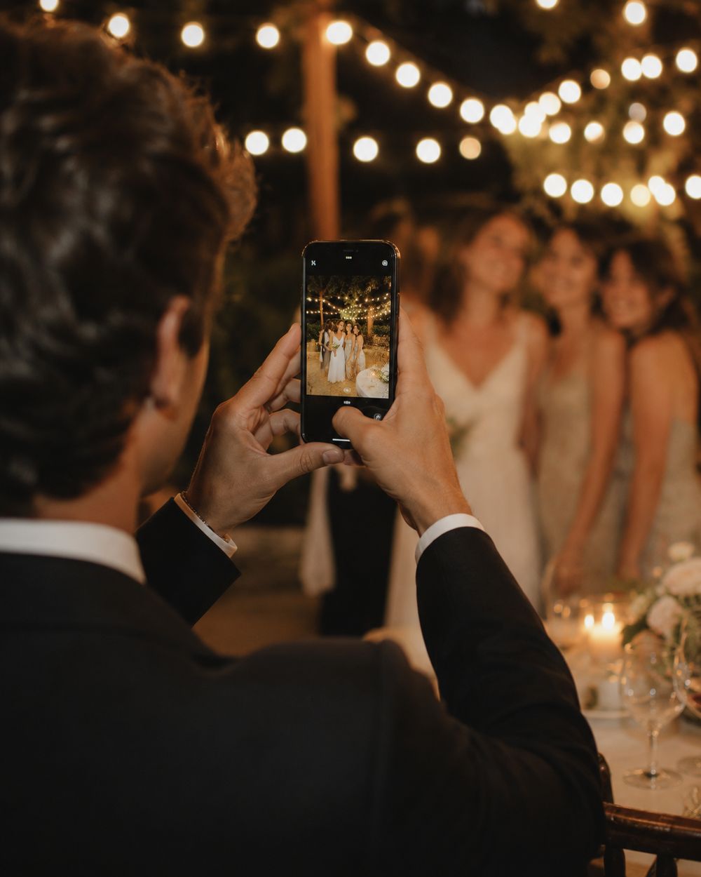 A wedding guest taking a photo on their phone at a reception